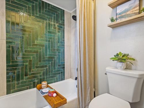 a bathroom with a tub and a toilet and a shower at Serene Lakeside Retreat- 3 Bdr Romantic Getaway in Winter Haven