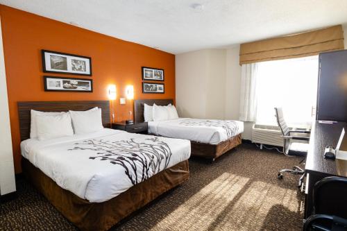a hotel room with two beds and a window at Sleep Inn Ormond Beach - Daytona in Ormond Beach