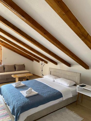 a bedroom with a blue bed and a couch at Apartmani Sara Trebinje in Zasad
