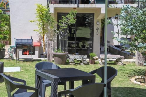 a patio with a table and chairs in a yard at ValZur Hospedaje-Habitación Acacias in Villa del Carbón