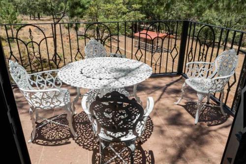 a patio with a table and chairs and a fence at Cabaña Amealco Pino in Amealco