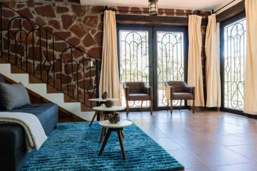 a living room with a couch and chairs and windows at Cabaña Amealco Pino in Amealco