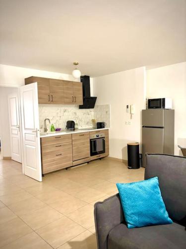 un salon avec un canapé et une cuisine dans l'établissement Le Doux Nougat - Montélimar, à Montélimar