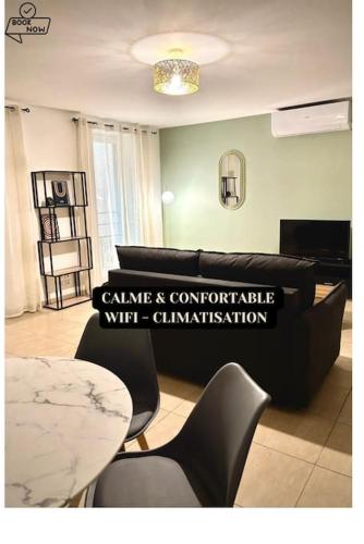 un salon avec un canapé et une table dans l'établissement Le Doux Nougat - Montélimar, à Montélimar