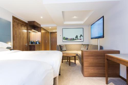 Un pat sau paturi într-o cameră la Cottons Hotel and Spa