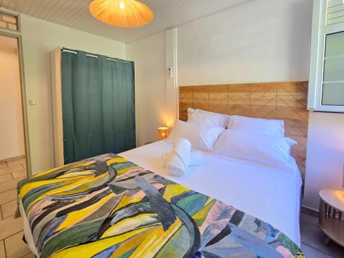 una camera da letto con un grande letto con una coperta colorata di Ti Kay Paradi T3 - Les pieds dans l'eau a Saint-Pierre