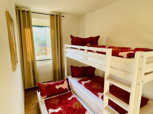 a bedroom with two bunk beds with red pillows at Kreativer Rückzugsort in der Burgenstadt Schlitz in Schlitz
