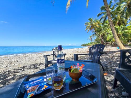 a table on the beach with a tray of food and drinks at Ti Kay Paradi T3 - Les pieds dans l'eau in Saint-Pierre