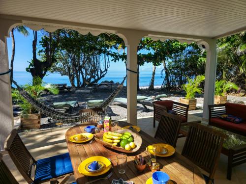 a table with a bowl of fruit on a porch at Ti Kay Paradi T3 - Les pieds dans l'eau in Saint-Pierre