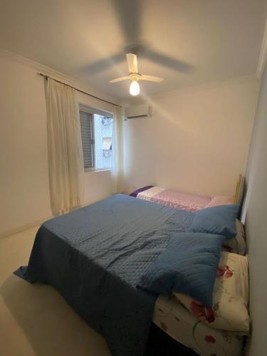Un dormitorio con una cama y un ventilador de techo. en Apt 72, en Santos