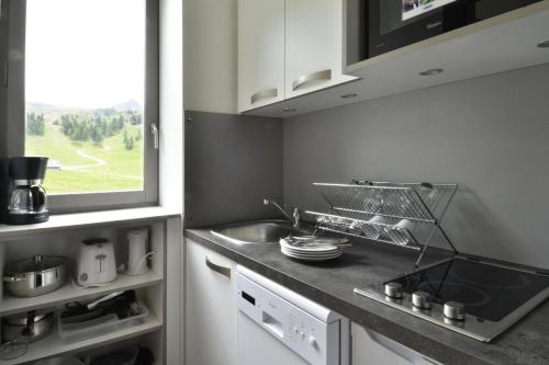 une cuisine avec un évier et un plan de travail dans l'établissement Residence 3000 - Studio pour 4 Personnes 24, à Mâcot La Plagne