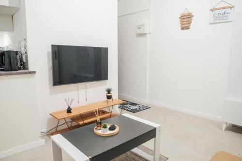 un soggiorno con tavolo e TV a schermo piatto di Appartement Cosy près de Paris et Disney a Neuilly-Plaisance