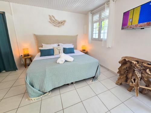 a bedroom with a bed with two towels on it at Villa Ti Kay Paradi - Accès plage direct in Saint-Pierre