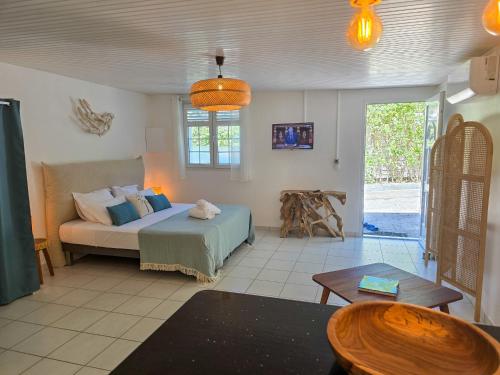 a living room with a bed and a table at Villa Ti Kay Paradi - Accès plage direct in Saint-Pierre