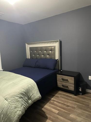 a bedroom with a bed with blue sheets and a nightstand at Nwk 457 RM 212-E in Newark