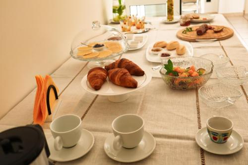 a table with plates of pastries and cups on it at B&B LA CASA DEL CASALE in Roseto degli Abruzzi