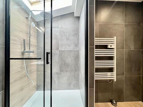 a shower with a glass door in a bathroom at T3 spacieux refait à neuf in Thyez