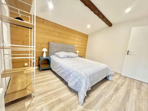 a bedroom with a bed and a wooden wall at T3 spacieux refait à neuf in Thyez