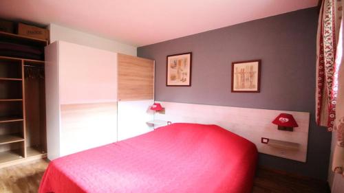 une chambre avec un lit rouge et un mur gris dans l'établissement Résidence Dame Blanche - DBA225 - APPT 1 CHAMBRE + CABINE - BALCON - 6 PERSONNES MAE-8991, à Narreyroux