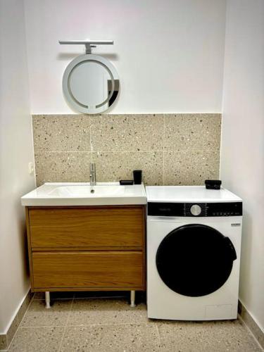 une petite cuisine avec un évier et une cuisinière dans l'établissement Le Chalet Urbain - Montélimar, à Montélimar