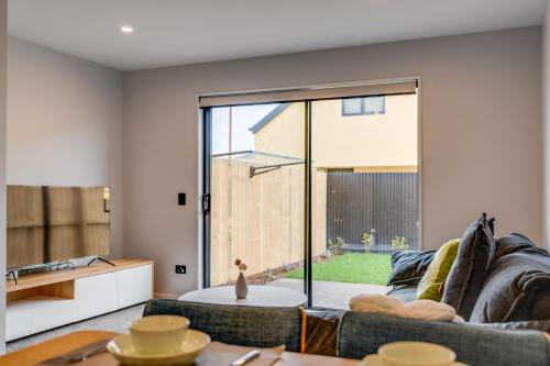 a living room with a couch and a table at Lovely 2BR Home close to Center in Christchurch