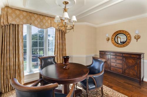 a dining room with a table and chairs and a window at Washington Duke Inn & Golf Club in Durham