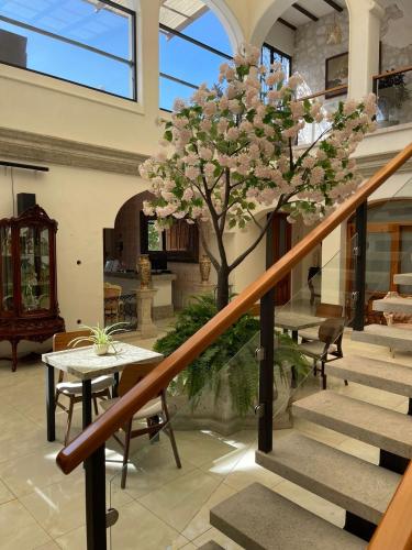 a staircase with a table and a tree in a building at Mansión Leonor in Bernal