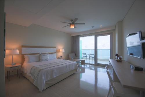 a bedroom with a large bed and a balcony at Las Americas Torre Del Mar in Cartagena de Indias