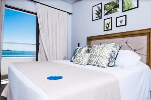 a bedroom with a white bed with a blue frisbee on it at Hotel Villareal São Francisco do Sul in São Francisco do Sul