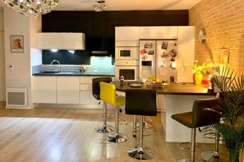 - une cuisine avec un comptoir et des chaises dans la chambre dans l'établissement Bel appartement 1 chambre - résidence de standing, à Aix-en-Provence