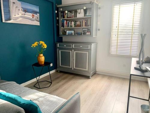 d'un salon avec des murs bleus et une table fleurie. dans l'établissement Bel appartement 1 chambre - résidence de standing, à Aix-en-Provence