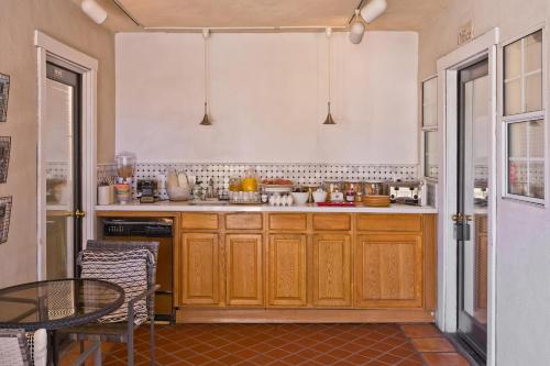 a kitchen with wooden cabinets and a table in it at La Maison Hotel - Adults Only in Palm Springs