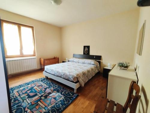 a bedroom with a bed and a rug at Appartamento Acero Rosso in Borno