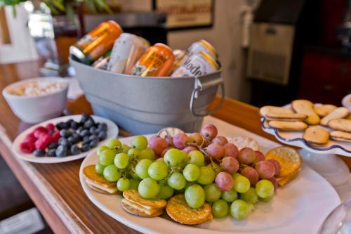a table topped with plates of grapes and other foods at La Maison Hotel - Adults Only in Palm Springs