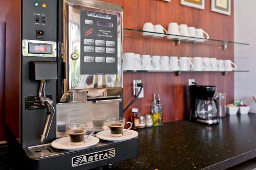 a coffee machine with two cups of coffee on a counter at La Maison Hotel - Adults Only in Palm Springs