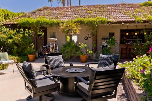 a patio with a table and chairs in front of a house at La Maison Hotel - Adults Only in Palm Springs