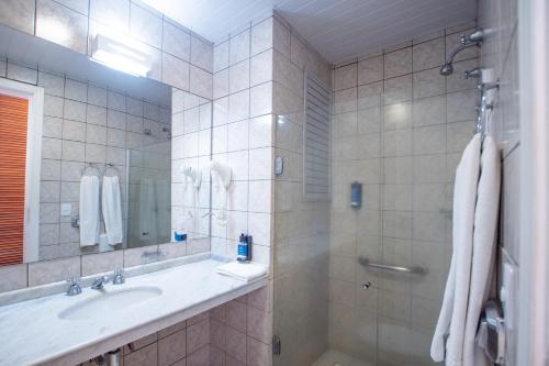 a bathroom with a sink and a shower at Hotel Villareal São Francisco do Sul in São Francisco do Sul