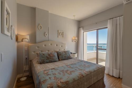 a bedroom with a bed with a view of the ocean at Hotel Villareal São Francisco do Sul in São Francisco do Sul