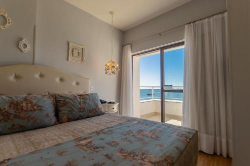 a bedroom with a bed with a view of the ocean at Hotel Villareal São Francisco do Sul in São Francisco do Sul