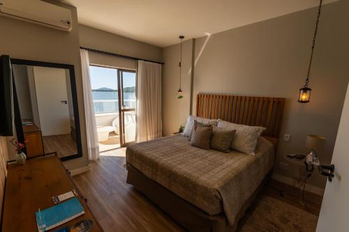 a bedroom with a bed with a view of the ocean at Hotel Villareal São Francisco do Sul in São Francisco do Sul