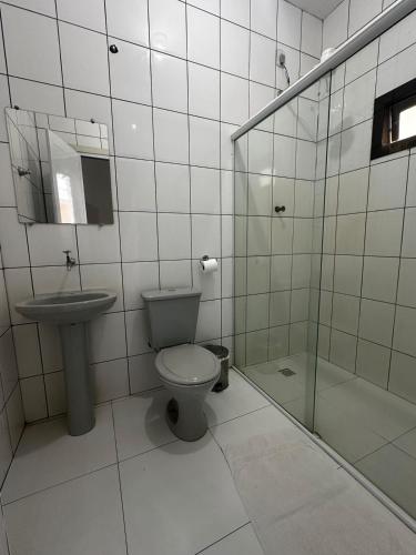 a bathroom with a toilet and a sink and a shower at Hotel Catarinense in Sorriso