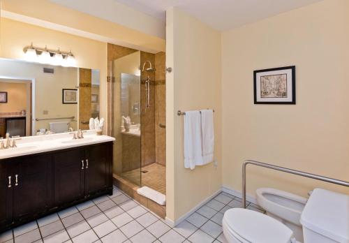 a bathroom with a shower and a toilet and a sink at La Maison Hotel - Adults Only in Palm Springs