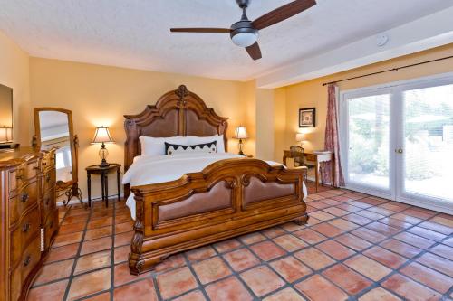 a bedroom with a large wooden bed in a room at La Maison Hotel - Adults Only in Palm Springs