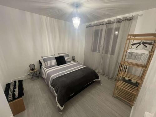 une chambre avec un grand lit dans une pièce blanche dans l'établissement Confort & Style au Cœur de Mulhouse, à Mulhouse