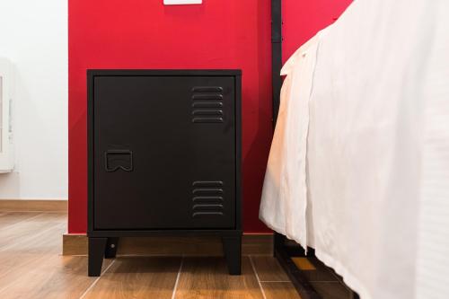 a black cabinet next to a bed in a room at Cicogna House in Villanova