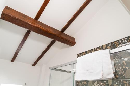 a wooden ceiling beam in a bathroom with a window at Cicogna House in Villanova