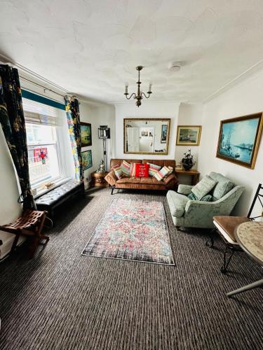 a living room with a couch and a rug at Seaway Beach House Looe Beach in Looe