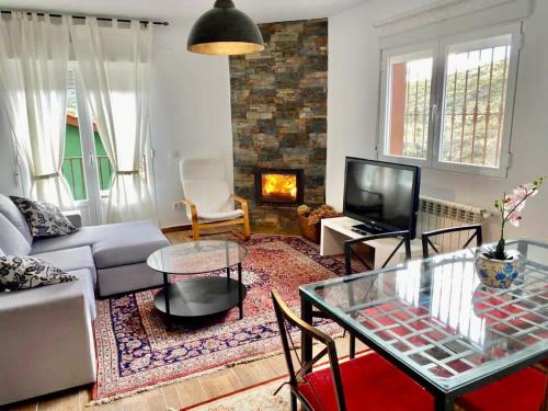 a living room with a couch and a table and a fireplace at Olival 2 in Las Herreras