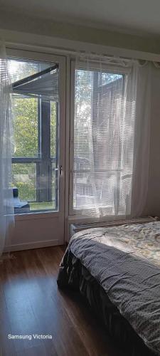 a bedroom with a bed and a large window at Peaceful Oasis by East Center in Helsinki