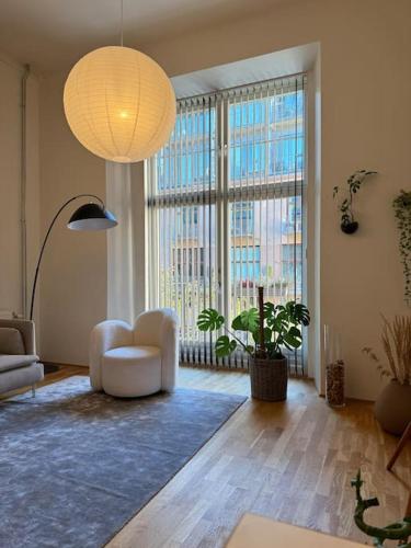 a living room with a couch and a large window at Botanical Bliss in OSLO! in Oslo